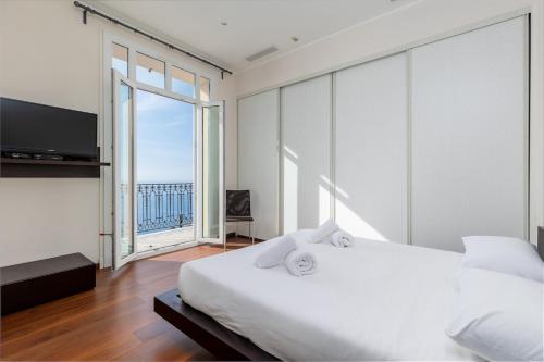 une chambre avec un lit blanc et une grande fenêtre dans l'établissement Les Floralies, large 3-room, sea and Monaco view, à Roquebrune-Cap-Martin
