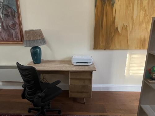 an office with a desk with a lamp and a chair at Charming Old Schoolroom in Daventry