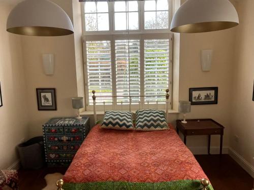 a bedroom with a bed and a large window at Charming Old Schoolroom in Daventry