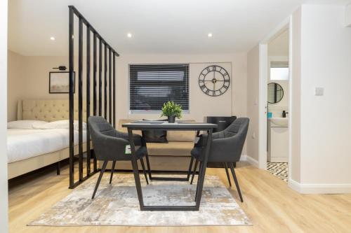 a dining room with a table and chairs and a bed at Modern Studio Apart Large Garden in Stoke on Trent