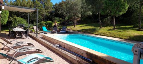 - une piscine avec des chaises, une table et une table dans l'établissement Villa d'Alzu, à Porto-Vecchio