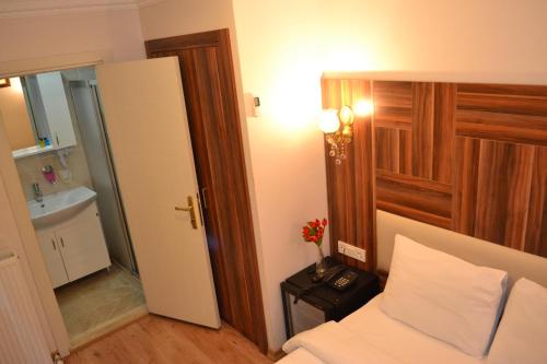 a small bedroom with a bed and a bathroom at New Fatih Hotel in Istanbul