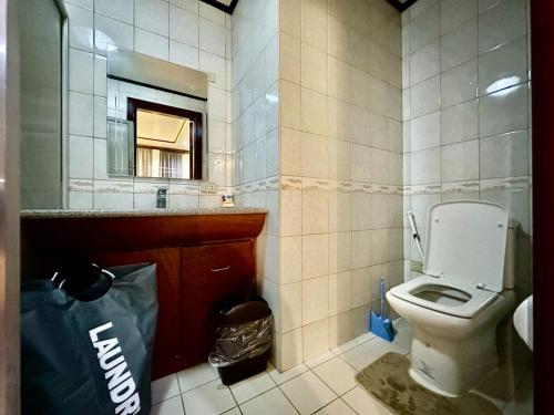 a bathroom with a toilet and a sink and a bag at Entire House at Club Morocco Beach Club Subic in Subic