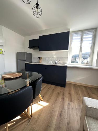 une cuisine avec des armoires noires et une table à manger dans l'établissement Appartement, à Pinon