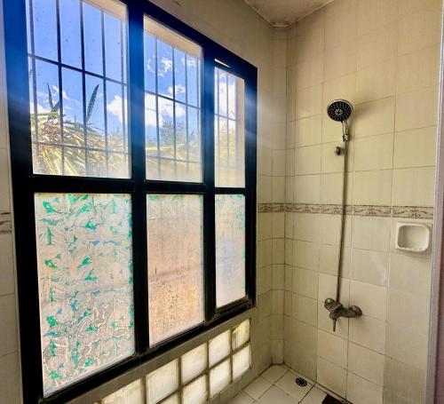 a bathroom with a window and a shower with a shower at Entire House at Club Morocco Beach Club Subic in Subic