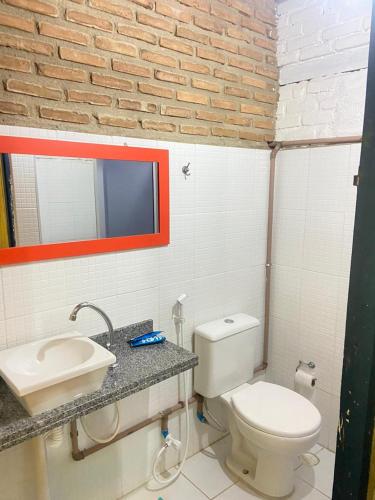 a bathroom with a white toilet and a sink at FAZENDA BOSQUE DAs PALMEIRAS in Itamaracá
