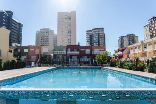 a large swimming pool in a city with tall buildings at Villa del Mar in Puebla de Farnals