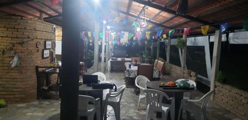 a room with tables and white chairs and flags at FAZENDA BOSQUE DAs PALMEIRAS in Itamaracá