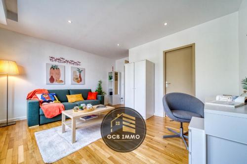 un salon avec un canapé bleu et une table dans l'établissement Le Clemenceau - Stade des alpes - Parking Gratuit, à Grenoble