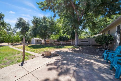a yard with two blue benches and a tree at Comfortable home near river access trail in Redding