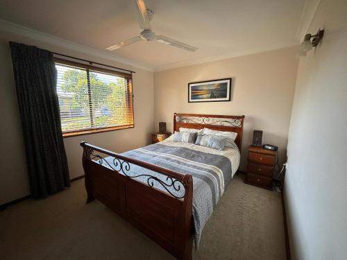 a bedroom with a bed and a window at Parkview 1- Black Head NSW in Hallidays Point