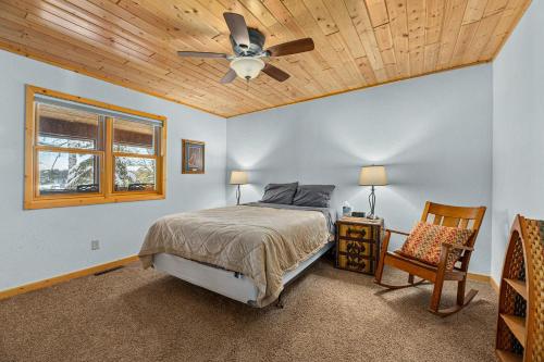 a bedroom with a bed and a ceiling fan at The Cedar Lakehouse in Lake Tomahawk WI in Lake Tomahawk