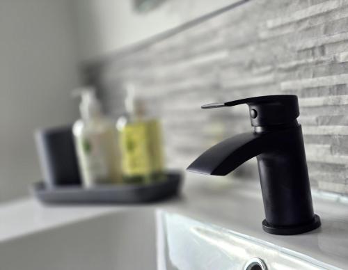 a black faucet on top of a kitchen sink at The Penthouse NY Loft Apartment in Barmouth