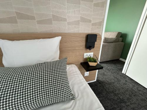 a bedroom with a bed and a tv on the wall at Nemea Appart Hotel La Boetie Bordeaux Pessac in Pessac