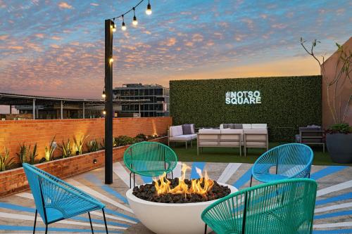 a patio with chairs and a fire pit on a rooftop at Aloft Guadalajara Sur in Guadalajara