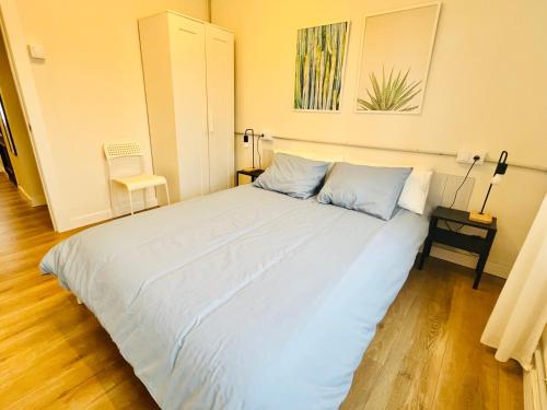 a bedroom with a large bed with blue pillows at Tu paraíso en Luanco in Luanco