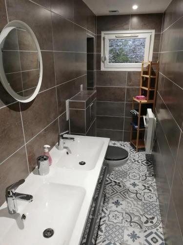 une salle de bain avec un lavabo blanc et un miroir dans l'établissement Appartement accueillant à Luynes, 60 m² avec jardin, à Luynes