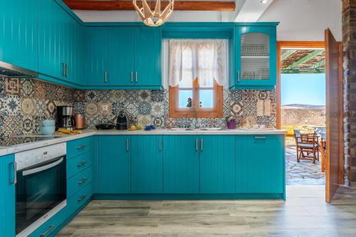 a kitchen with blue cabinets and a window at Archontiko Keli in Katákoilos