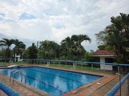 a large swimming pool in front of a house with trees at MARKEZ Campestre in Cumaral