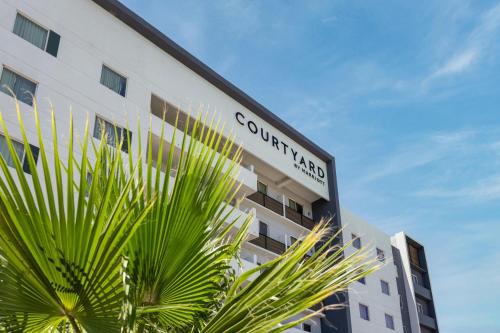 a building with a sign on the side of it at Courtyard by Marriott Hermosillo in Hermosillo