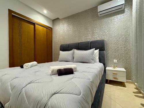 a bedroom with a large white bed with at Comfort & Style Apartment in Kenitra