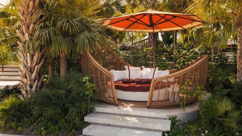 a wicker swing with an umbrella in a garden at Jumeirah Marsa Al Arab Dubai in Dubai