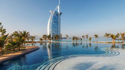 a swimming pool with a tall building in the background at Jumeirah Marsa Al Arab Dubai in Dubai