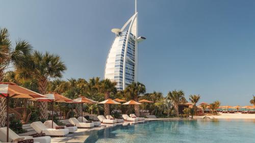 a hotel with a swimming pool and a tall building at Jumeirah Marsa Al Arab Dubai in Dubai