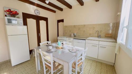 - une cuisine avec une table blanche et des appareils électroménagers blancs dans l'établissement location proche des plages, à Sainte-Marie de Ré