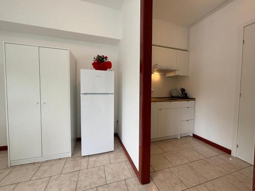 a room with a white refrigerator and a kitchen at Garden Residence in Quingentole
