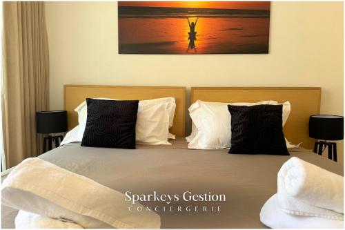 a bed with black and white pillows in a bedroom at SG13 l Appartement en Résidence l Oasis palms in Mont Choisy
