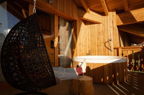 a bathroom with a large tub and a sink at Pineta Nature Resort - Wellness & SPA in Coredo