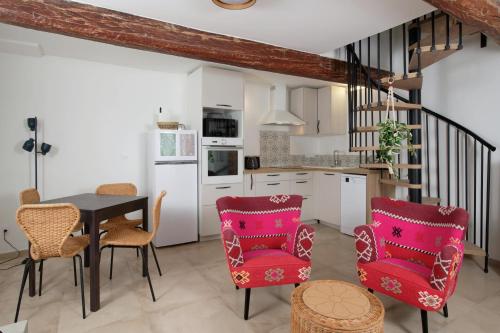 une cuisine avec une table et des chaises ainsi qu'un escalier dans l'établissement Gîte 2 places, LES LUCIENS, meublé 3 étoiles, à Saint-Gély-du-Fesc