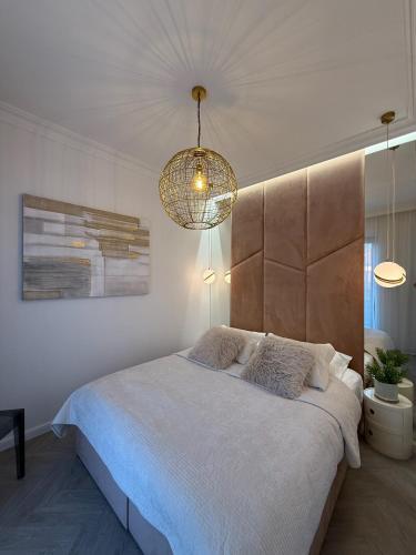 a bedroom with a large bed and a chandelier at Apartament Pod Żaglami 4 in Sława
