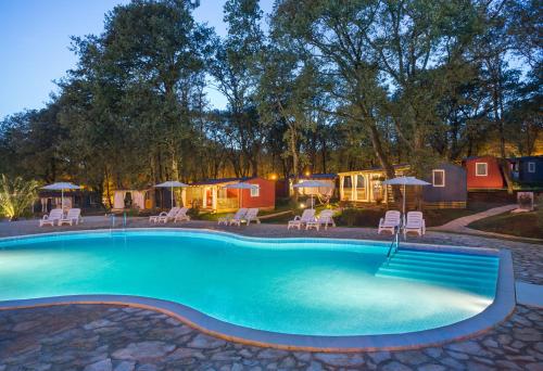 a swimming pool in front of a group of tents at Aminess Planet Camping Holiday Homes Maravea in Novigrad Istria