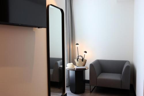 a room with a chair and a mirror at Silken Saaj Maar - Adults Only in Puerto de la Cruz