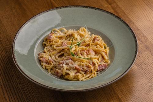 a bowl of pasta with meat and cheese on a table at HIDE PARK Hotel in Vinnytsya