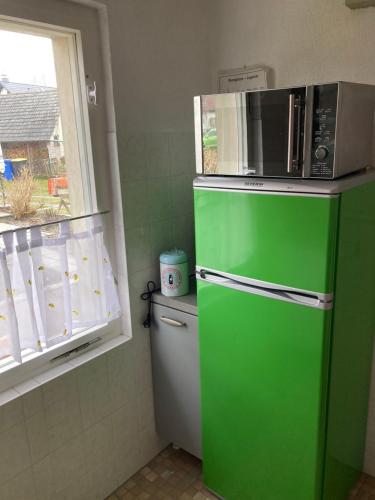 a green refrigerator with a microwave on top of it at Rast am Park in Bad Muskau