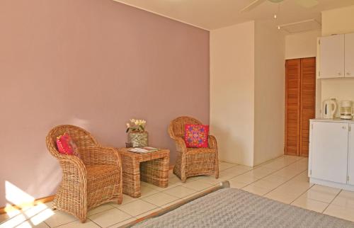 a living room with two chairs and a table at Pega Pega Apartments in Oranjestad