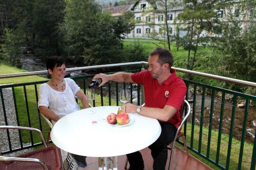 a man and a woman sitting at a table with a plate of fruit at Apartmenthaus Franz Kleindienst in Deutschlandsberg