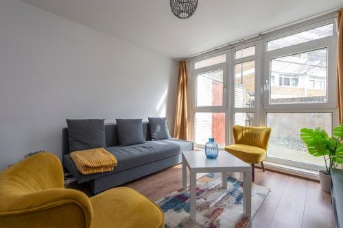 a living room with a couch and two chairs and a table at Lovely 2-bed 20 mins to central London in London
