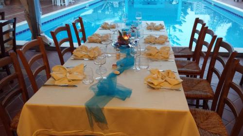 a table set for a party with a yellow table cloth at Hotel L'Ulivo in Girasole
