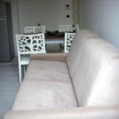 a couch in a room with two chairs and a table at Appartamenti Romita in Cupra Marittima