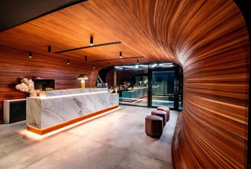 a lobby with a large wooden wall and a counter at Silken Saaj Maar - Adults Only in Puerto de la Cruz