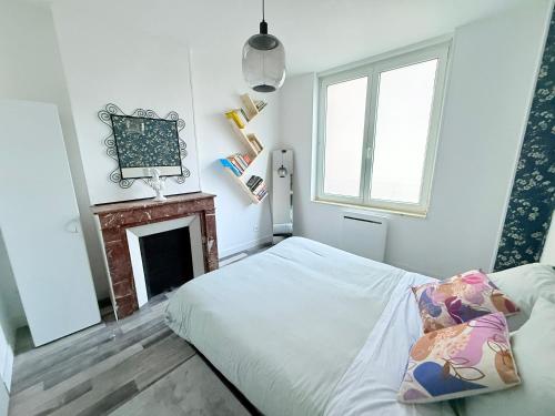 - une petite chambre avec un lit et une cheminée dans l'établissement les 1001 Briques, à Saint-Quentin