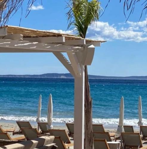 a group of lounge chairs on the beach at Maison Piscine Chauffée Privée a 200 mn de la Plage in Rayol-Canadel-sur-Mer