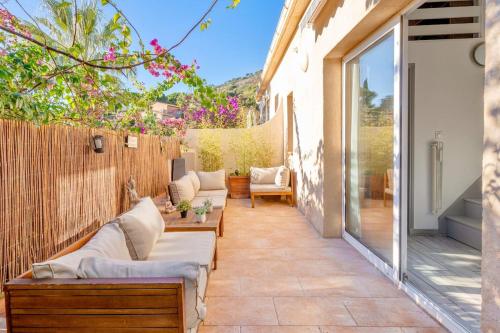 a patio with two couches and a table at Maison Piscine Chauffée Privée a 200 mn de la Plage in Rayol-Canadel-sur-Mer