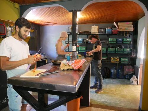 a group of men standing in a kitchen preparing food at CASA KAYAM Art Hostel Coliving Coworking in Guatapé