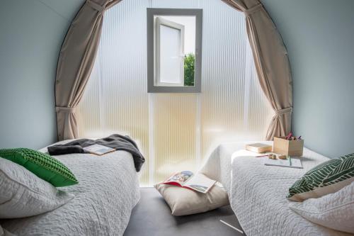 une chambre avec deux lits et une fenêtre dans l'établissement Camping le Rural, à Tibiran-Jaunac