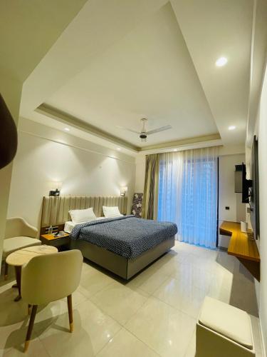Un dormitorio con una cama, un sofá y una silla. en Regal stay, en Lucknow